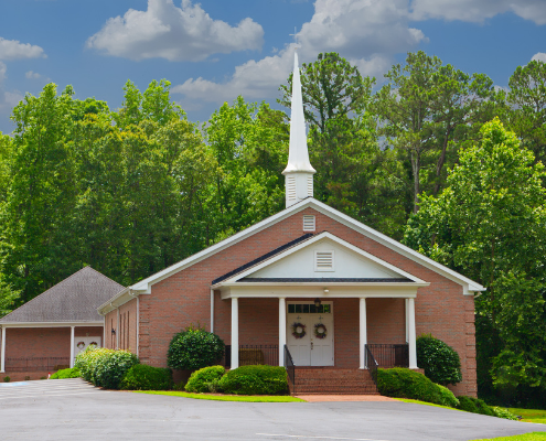 Small church with tress behind it
